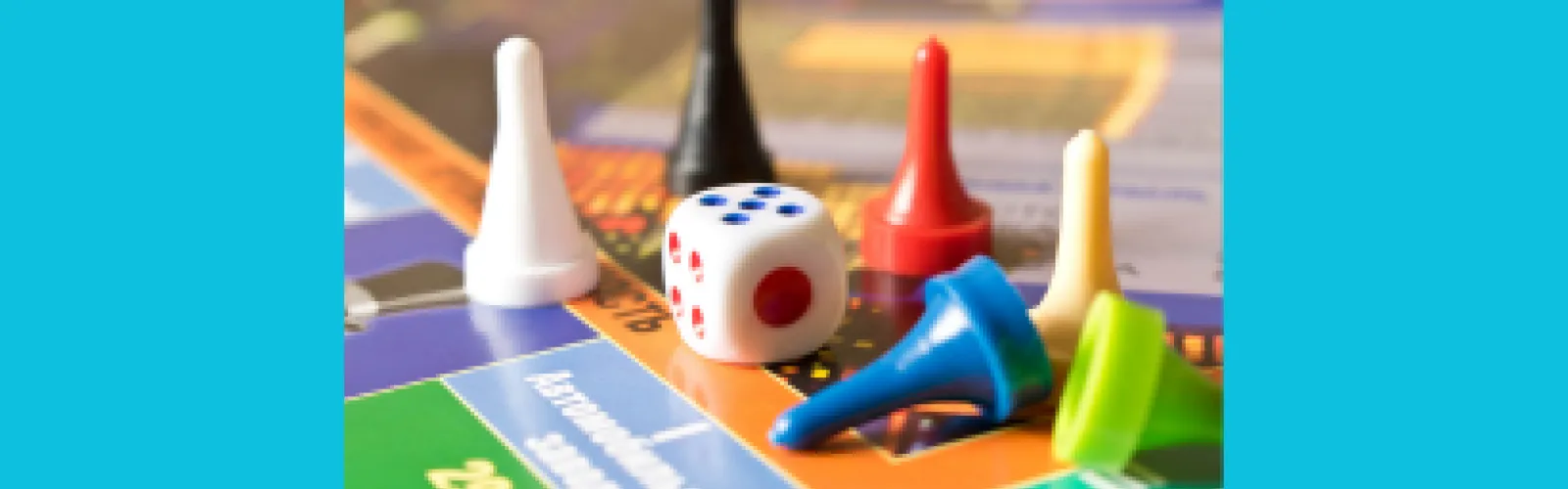 Various colors of game pieces, dice on a bright blue background